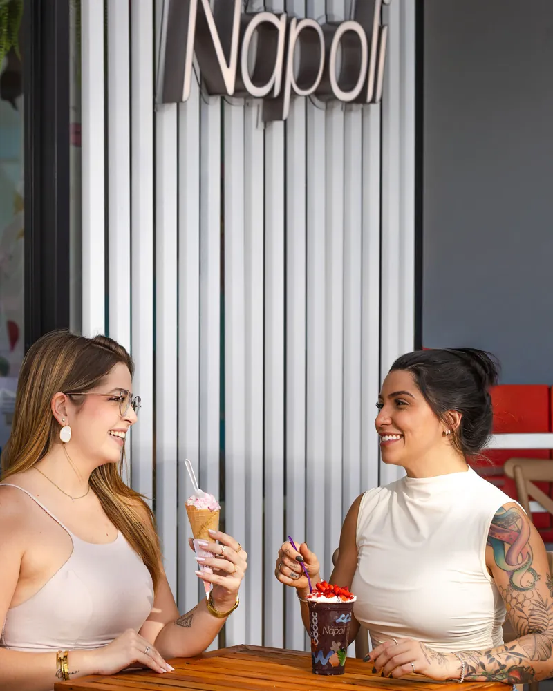 Duas amigas tomando sorvete na frente da loja Nápoli